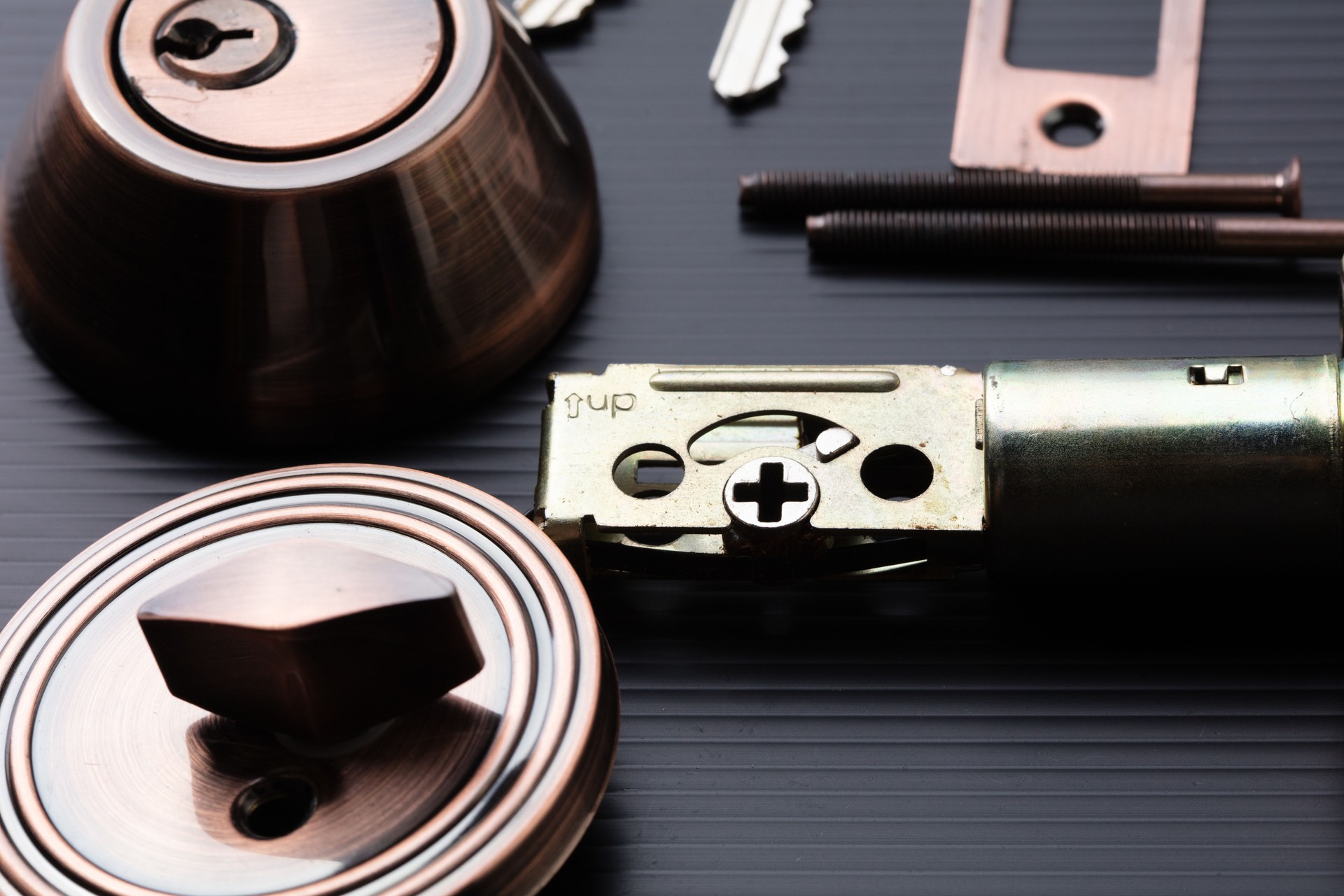 Small parts of Deadbolt lock to protect security safety on door window house. Incomplete many parts of deadbolt lock before assemble to door window with key over black background